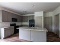 Modern kitchen with granite countertops, gray cabinets, stainless steel appliances, and an island with a sink at 358 Forkview Dr, Lawrenceville, GA 30044