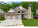 Charming brick home with three-car garage, manicured lawn, and stately stone chimney at 5826 Sarazen Trl, Douglasville, GA 30135