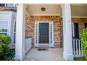 Elegant front entrance with a classic black door, brick facade, and white trim accents at 210 Creekside Overlook, Hiram, GA 30141