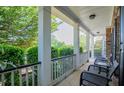 Relaxing front porch view featuring comfortable seating, decorative columns, and serene outdoor scenery at 210 Creekside Overlook, Hiram, GA 30141