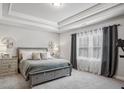 Serene bedroom with tray ceilings, neutral tones, and plenty of natural light at 821 Ethereow Ct, Lawrenceville, GA 30046
