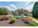 Beautiful backyard oasis featuring a sparkling in-ground pool, manicured landscaping, and a stone patio at 2439 Huntington Park Nw Dr, Acworth, GA 30101