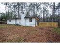 View of the back of the house showing a brick chimney and a wooden deck at 5101 Rockbridge Rd, Stone Mountain, GA 30088