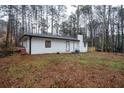 View of the back of the house showing the brick chimney and a wooden deck at 5101 Rockbridge Rd, Stone Mountain, GA 30088