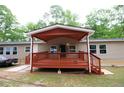Back porch with painted wooden deck and awning on a home with light tan vinyl siding at 208 Holiday Way, Carrollton, GA 30116
