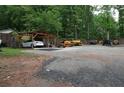 Large parking area with a covered spot for a car and various pieces of heavy equipment at 208 Holiday Way, Carrollton, GA 30116