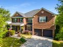 Charming brick home featuring a two-car garage, well-kept lawn, covered porch and an American flag at 4215 Idlewood Dr, Cumming, GA 30040