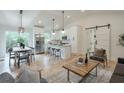 Open-concept living area with hardwood floors, modern lighting, and an adjacent kitchen at 4901 Prince Se Rd, Smyrna, GA 30082