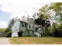 Green two-story home with a two-car garage and mature trees at 114 Summer Glen Pl, Dallas, GA 30157