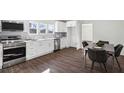 Modern kitchen with stainless steel appliances, white cabinetry, and an adjacent dining area for convenient meals at 1721 Hortense Nw Pl, Atlanta, GA 30318