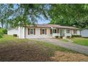 A side view of a single-story home featuring a long driveway and detached garage at 46 Forkwood Cir, Hiram, GA 30141