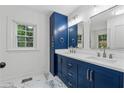 Stylish bathroom features double sinks, custom blue cabinets, and modern fixtures at 2590 Eastwood Dr, Decatur, GA 30032