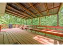 Inviting covered back deck with wooden floors, a bench, and a grill, perfect for outdoor entertaining at 3349 Old Atlanta Rd, Suwanee, GA 30024