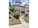 Charming brick townhome with a covered front porch and well-manicured landscaping, and concrete stairs at 3658 Hidden Valley Cir, Lawrenceville, GA 30044