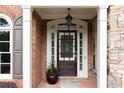 Elegant front entrance featuring a dark wood door, white columns, and lush landscaping at 4231 Shamans Dr, Marietta, GA 30062