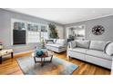 Bright living room with hardwood floors, a large window, and gray couches at 1496 S Hairston Rd, Stone Mountain, GA 30088