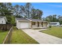 Side view of renovated brick home featuring a garage and well-maintained lawn at 354 Tarragon Sw Way, Atlanta, GA 30331