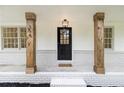 Covered front porch with wooden columns and black front door with windows at 354 Tarragon Sw Way, Atlanta, GA 30331