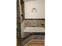 Bathroom featuring a tile surround soaking tub and stylish lighting fixtures at 170 White Rose Ln, Temple, GA 30179