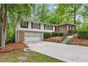 Two-story home featuring a front-facing garage, brick accents, and a vibrant red front door at 2488 Fontainebleau Dr, Dunwoody, GA 30360