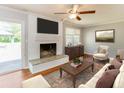 Bright living room featuring a white brick fireplace, wood floors, and a comfortable sofa at 5702 Forest Dr, Acworth, GA 30102