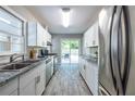 Modern kitchen features white cabinetry, stainless steel appliances, granite countertops, and wood-look flooring at 1875 Fairway Ne Cir, Atlanta, GA 30319