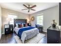 Comfortable bedroom with a ceiling fan, two windows, hardwood flooring, and a tufted headboard at 1875 Fairway Ne Cir, Atlanta, GA 30319