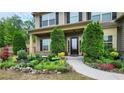 Charming home featuring a landscaped front yard with colorful flowers and manicured evergreens at 2022 Boxwood Ln, Canton, GA 30114