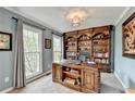 Bright office featuring custom built-in shelving, desk, and neutral paint with ample natural light at 3160 Bailey Cove Ct, Dacula, GA 30019
