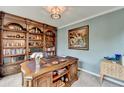 Well-appointed office with a large wooden desk, custom bookshelves, and neutral paint at 3160 Bailey Cove Ct, Dacula, GA 30019