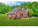 A well-kept two-story brick home showcasing its landscaped yard and part of the driveway at 2498 Highway 212, Covington, GA 30016