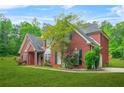 Side view of a beautiful two-story brick house featuring a well-maintained lawn and landscaping at 2498 Highway 212, Covington, GA 30016