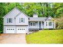 Charming two-story home featuring light gray siding, blue shutters, and a two-car garage at 4822 Westbourne Dr, Powder Springs, GA 30127
