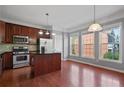 Bright eat-in kitchen featuring stainless steel appliances, granite countertops, and hardwood flooring at 1530 Wehunt Se Cir # 19, Smyrna, GA 30082