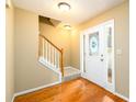 Bright foyer featuring hardwood floors, a staircase, and a front door with decorative glass at 2055 Springer Walk, Lawrenceville, GA 30043