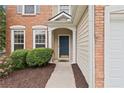 Inviting front entrance with a blue door, manicured bushes, and fresh mulch at 216 Diamond Valley Pass, Canton, GA 30114