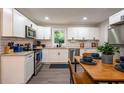 Modern kitchen featuring white cabinets, stainless steel appliances, granite counters, and a dining area at 831 Catherine St, Forest Park, GA 30297