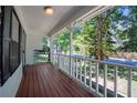 Inviting covered porch featuring wood flooring, white railing, and a view of the surrounding greenery at 488 Russell Rd, Lawrenceville, GA 30043