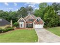 Charming brick two-story home with well-manicured lawn and a two-car garage at 7020 Grand View Way, Suwanee, GA 30024