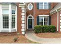Close up of brick home with blue shutters and rounded front door and bay window at 7020 Grand View Way, Suwanee, GA 30024