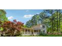 Charming two-story home with front porch, surrounded by trees and a grassy yard beneath a blue sky at 151 Grandma Branch Rd, Grantville, GA 30220