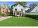 Charming two-story home with a manicured lawn, walkway, and fresh landscaping at 1671 Laurel Nw Ave, Atlanta, GA 30318