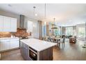 Modern kitchen with an island, stainless steel appliances, brick accent wall, and hardwood floors at 175 Stovall Se St, Atlanta, GA 30316