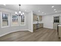 Eat-in kitchen showcasing stainless steel appliances, new floors, updated cabinets, modern lighting and view to yard at 2017 Allwood Ct, Lawrenceville, GA 30044
