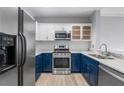 Modern kitchen with stainless steel appliances, blue cabinets, and granite countertops at 850 Piedmont Ne Ave # 2509, Atlanta, GA 30308