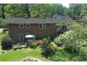 Aerial view of brick home featuring a lush backyard, patio, and wooded surroundings at 4360 Pleasant Forest Dr, Decatur, GA 30034