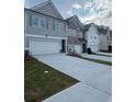 View of newly built gray and white townhomes with a two car garage and lawns at 6424 Rosetta Dr, South Fulton, GA 30331