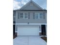 Charming townhome with gray siding, gray shutters, and a two-car garage at 6424 Rosetta Dr, South Fulton, GA 30331
