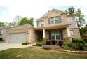 Charming two-story brick home featuring a manicured lawn, colorful flower beds, and inviting front porch at 1142 Terrasol Rdg, Lilburn, GA 30047