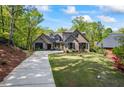 Charming brick home with a well-manicured lawn and long driveway leading to a three-car garage at 1188 Woodtrace Ln, Auburn, GA 30011